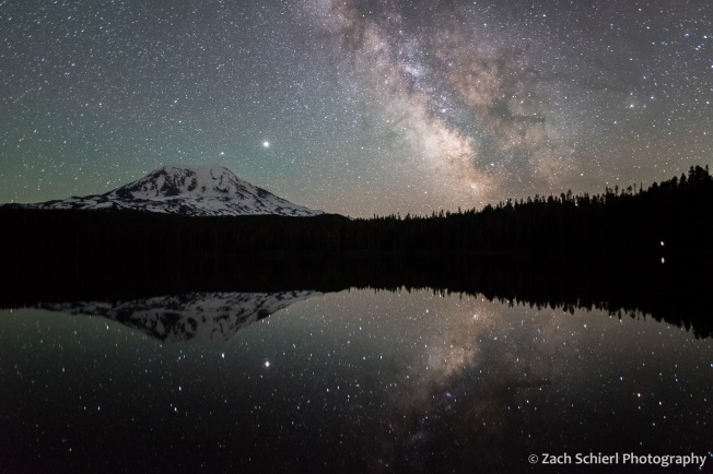 Reflection of Milky Way and volcanic cone in a tranquil lake.