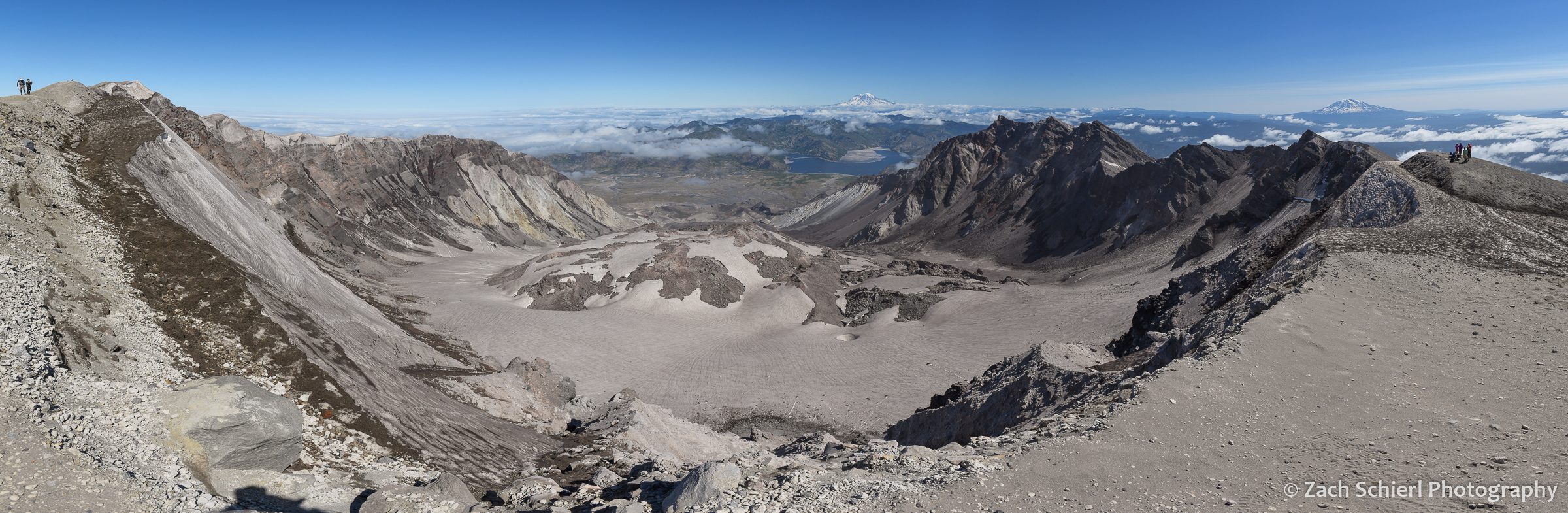 Panorama of a large volcanic crater with a mound of solidified lava in the center